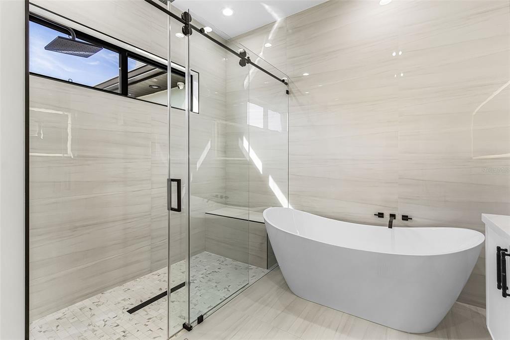 Atenia primary bathroom with soaking tub, glass shower, double vanity and premium finishes