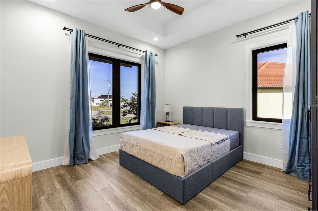 Atenia secondary bedroom with blue bed and two windows