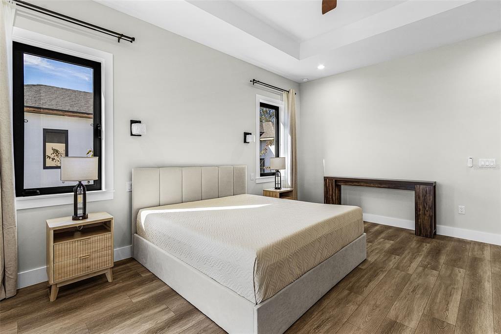 Additional Atenia primary bedroom angle with bed, tray ceiling and window