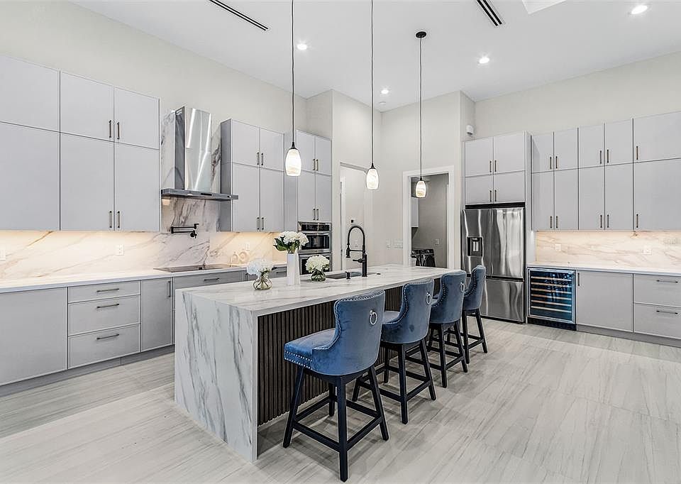 Atenia kitchen with quartz island, cabinetry and open living