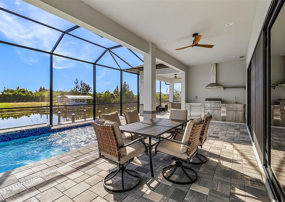 Atenia screened lanai, pool, outdoor kitchen, dining area, canal and dock