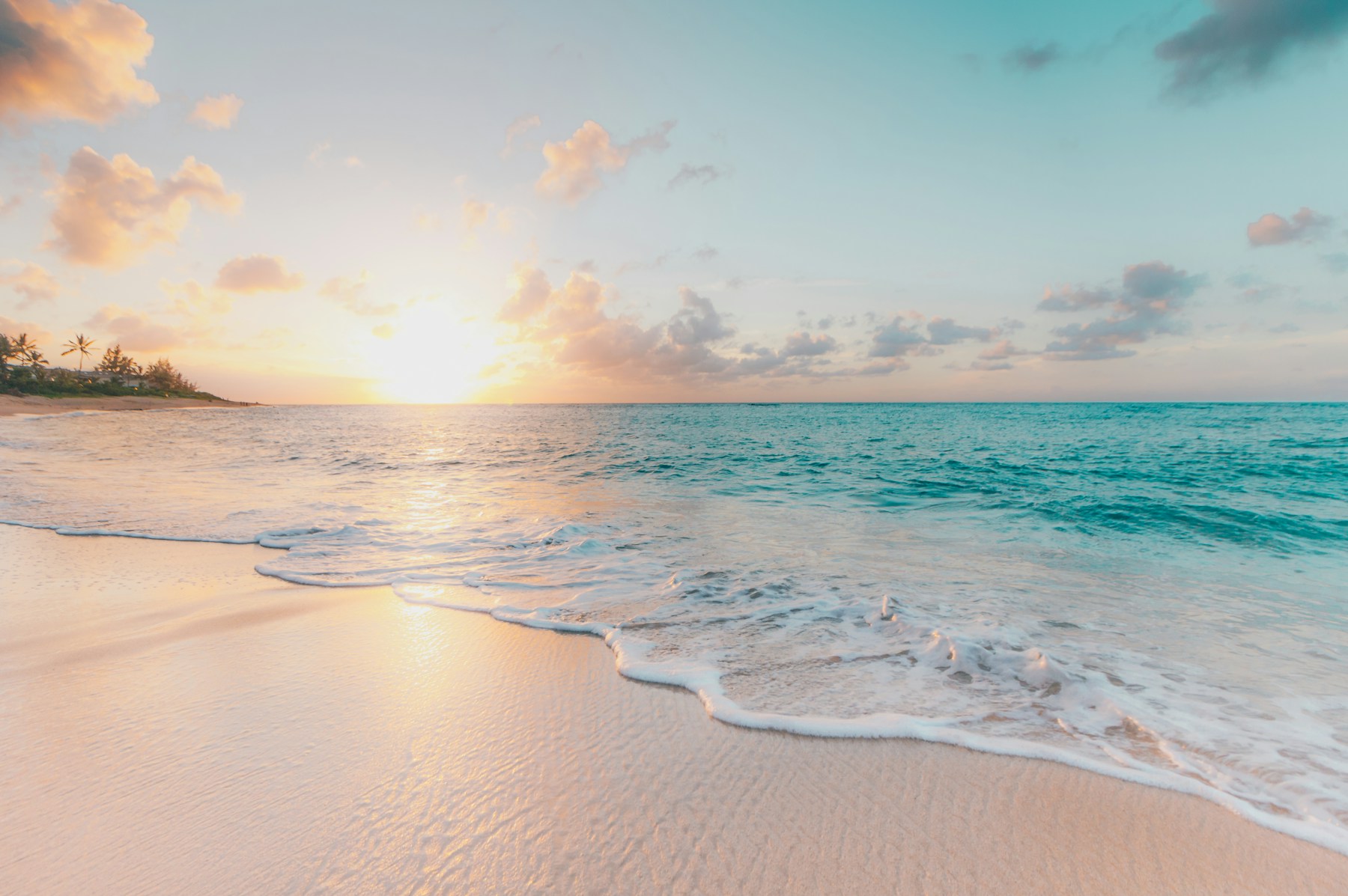 Wide Gulf beach with clear blue water and pale sand